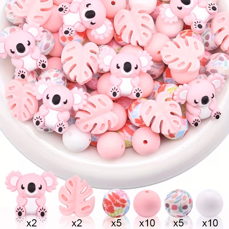 A 34-piece DIY silicone bead set featuring pink 3D koala and monstera leaf focal beads, floral printed beads, and solid pink and white rounds by Woodland Beads & Co.