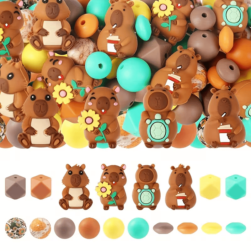 A DIY bead assortment from Woodland Beads & Co featuring four different capybara focal beads holding a sunflower, a coffee cup, and a turtle, alongside teal, yellow, and brown silicone beads.